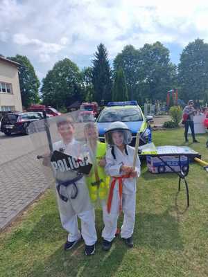 Dzieci, uczestniczące w pikniku przedstawiające sprzęt policyjny.