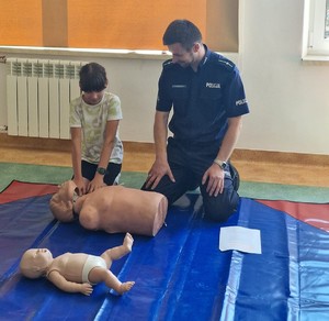 Policjant prowadzący prelekcję w Szkole Podstawowej we Frysztaku.