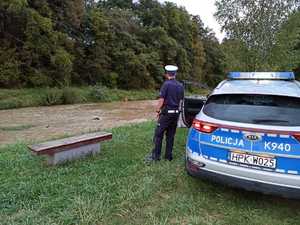 Policjant kontrolujący poziom wody w rzece.