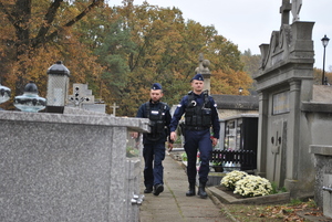 Patrol Policji kontrolujący porządek publiczny na cmentarzu.