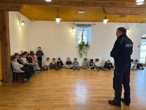 Dzielnicowy z Posterunku Policji w Wiśniowej rozmawia z uczestnikami półkolonii