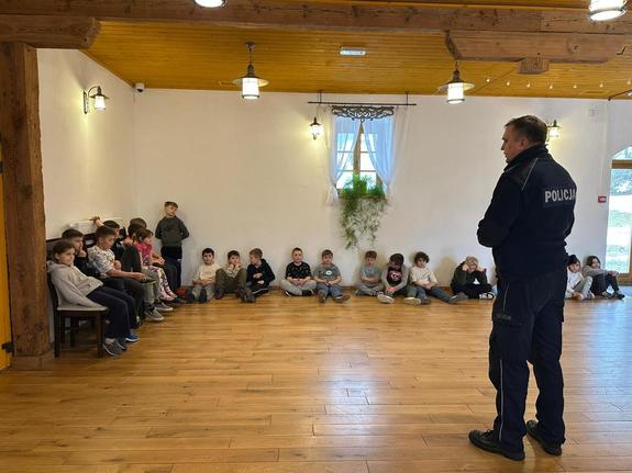 Dzielnicowy z Posterunku Policji w Wiśniowej rozmawia z uczestnikami półkolonii