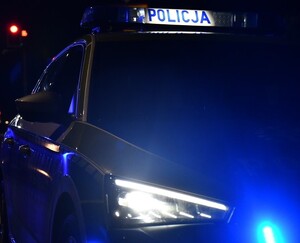 Radiowóz policyjny z włączonymi światłami uprzywilejowania.
