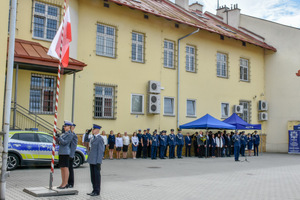 Moment podniesienia flagi państwowej. W tle widać zgromadzonych uczestników uroczystości.